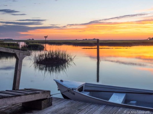 A small boat tied to a dock at sunrise for-sale online